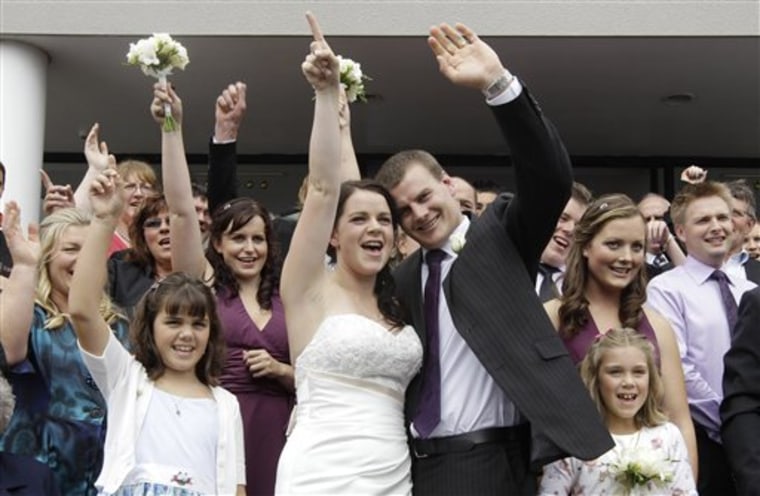 Newlyweds Emma Howard and Chris Greenslade cheer for a group photo after their wedding, Friday, just days after the bride was pulled from the rubble of the earthquake-devastated Pyne Gould Corporation in Christchurch, New Zealand. 